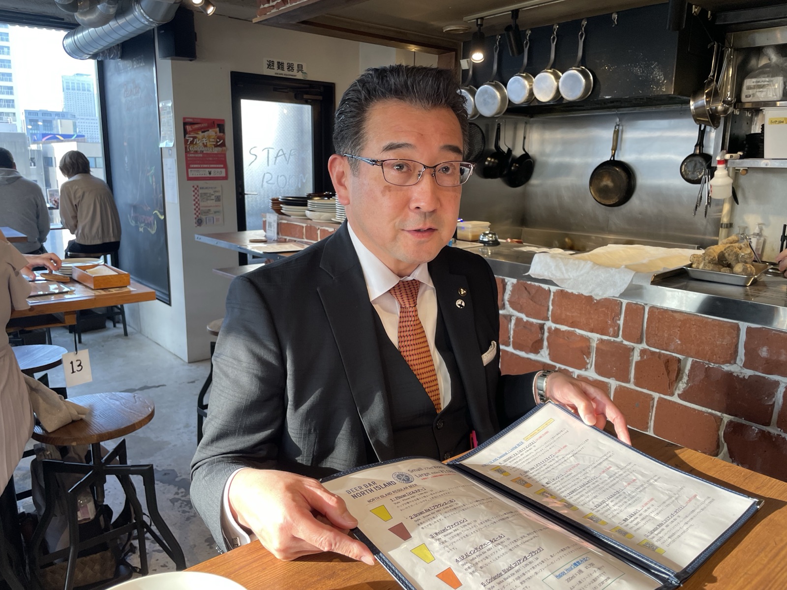 メニューを手に語るＳＯＣブルーイング株式会社 坂口典正氏
