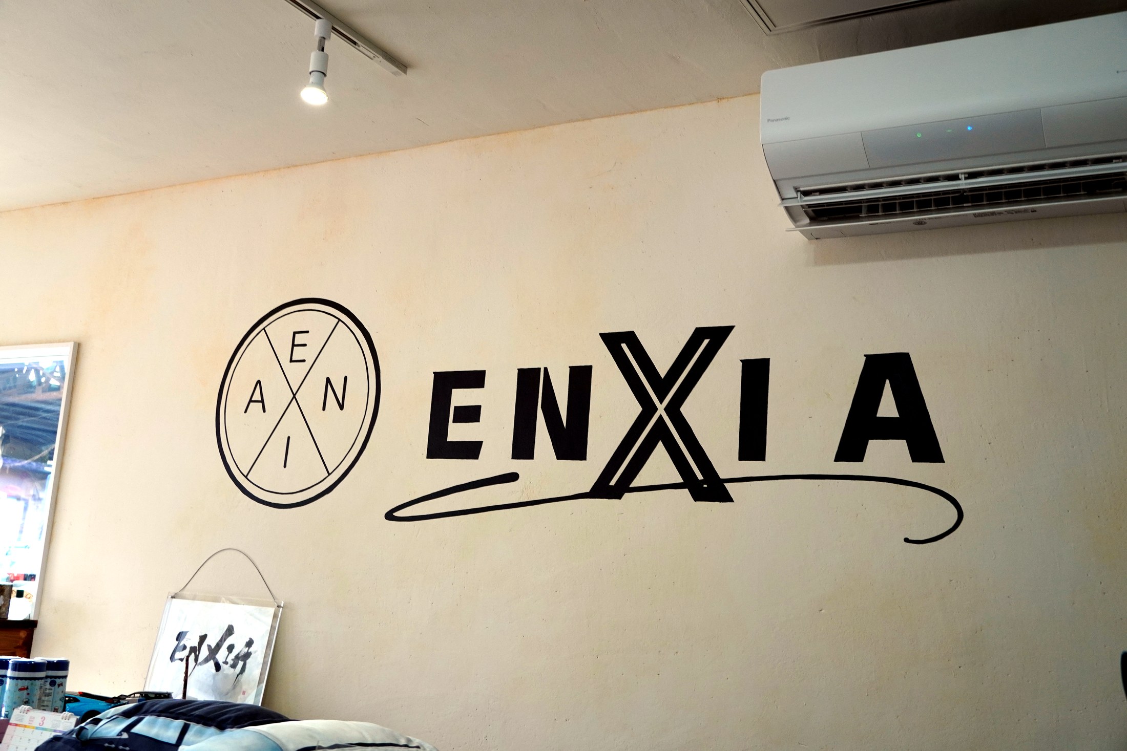 株式会社ENXIAのロゴサイン（Xと時計のマーク）