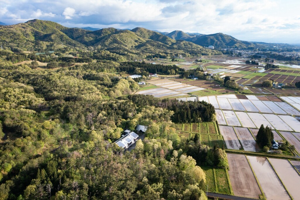 林の中に建つジョイ・コス本社と周辺の田園風景(岩手県花巻市)