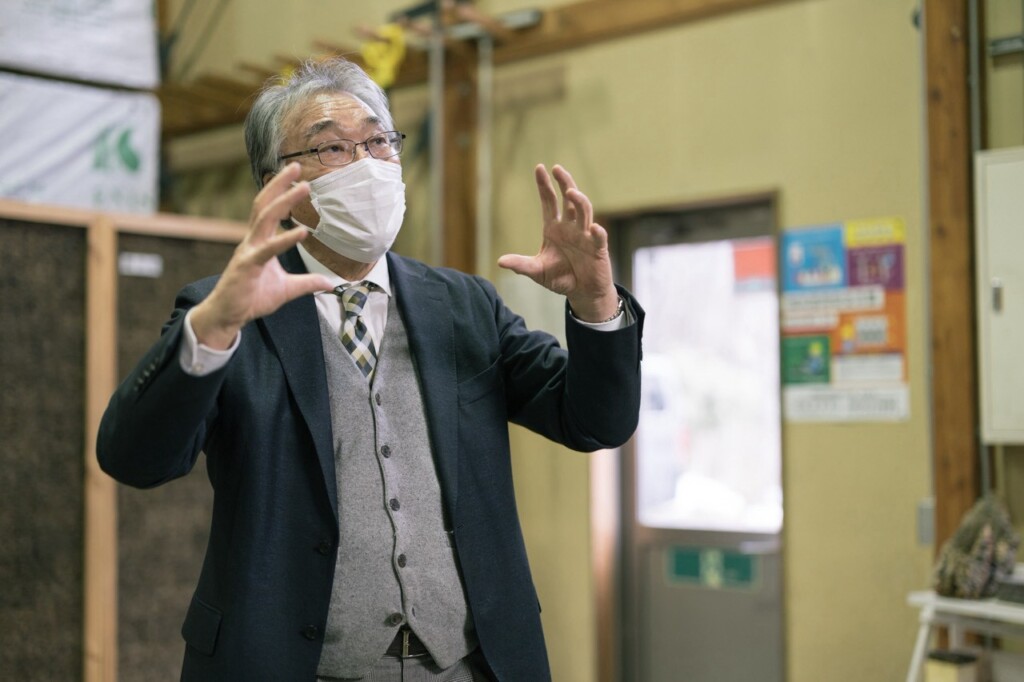 工場で身ぶりを交えて説明する佐藤益夫会長