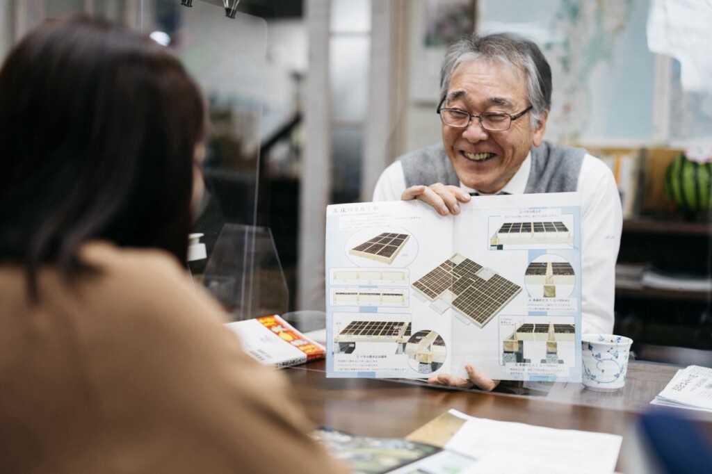 資料を手に笑顔で話す佐藤益夫会長