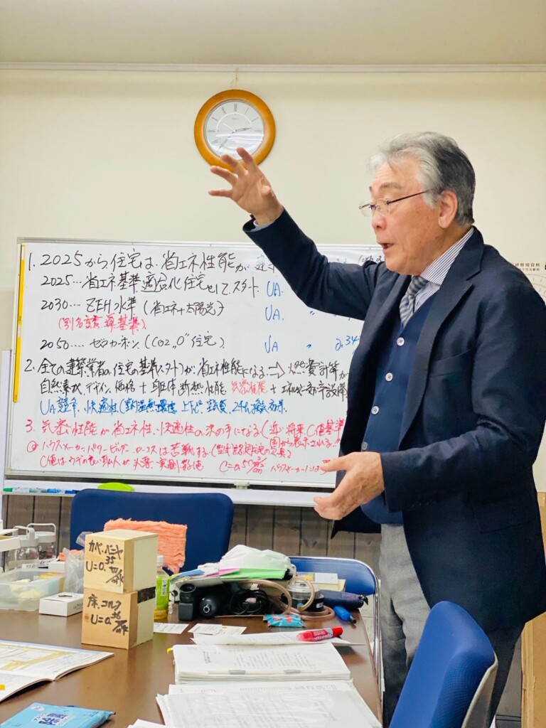 ホワイトボードで省エネ基準の流れを説明する佐藤益夫会長