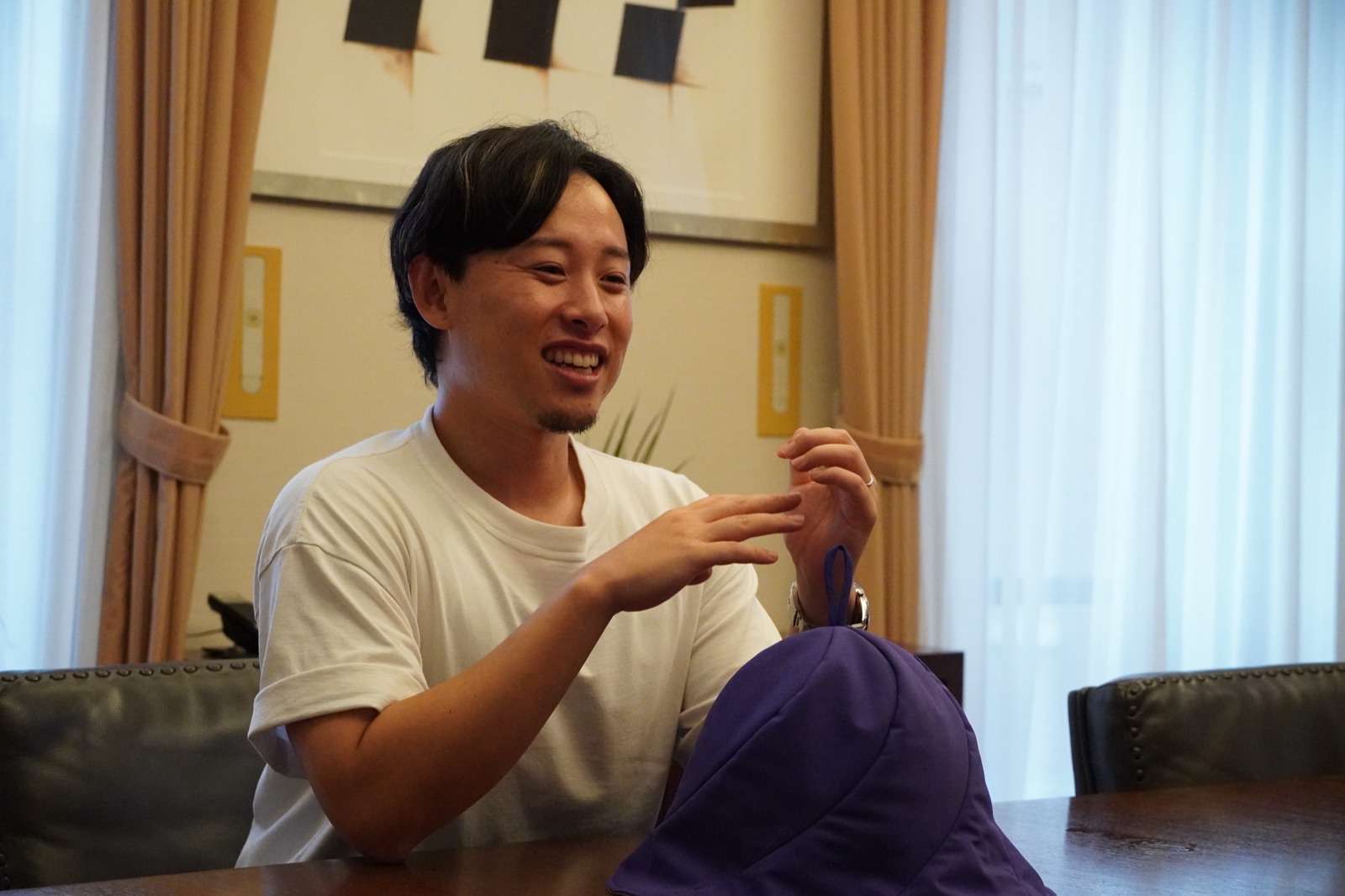サウナハットの特徴を笑顔で説明する加納優誉氏