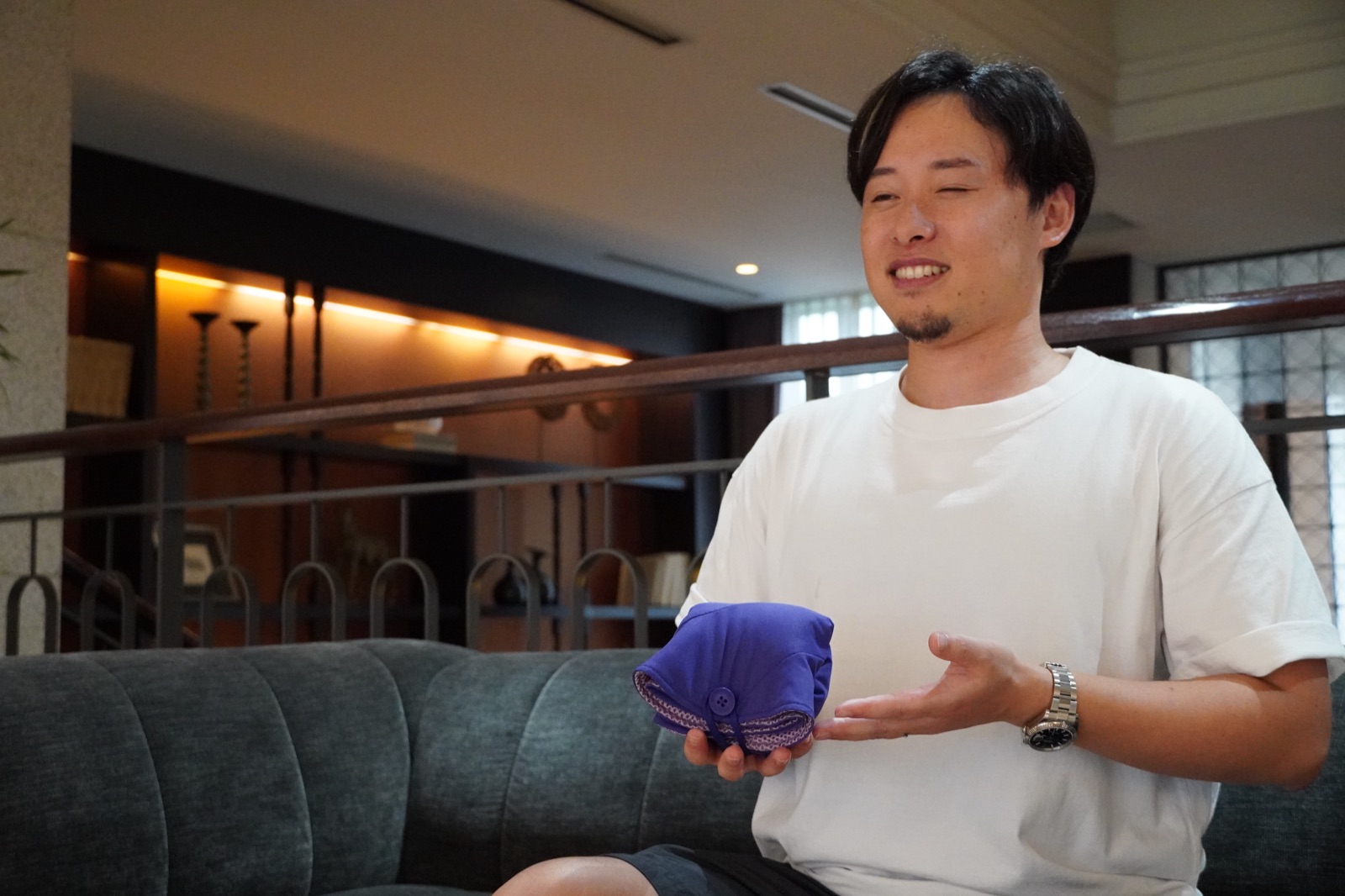 折り畳んだサウナハットを手に説明する加納優誉氏
