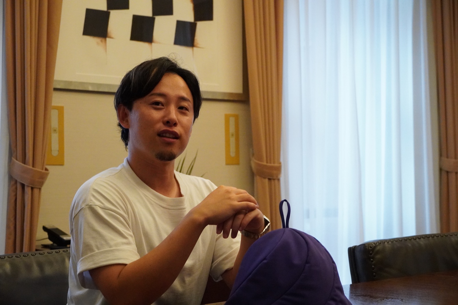 テーブルに置いたサウナハットについて話す加納優誉氏