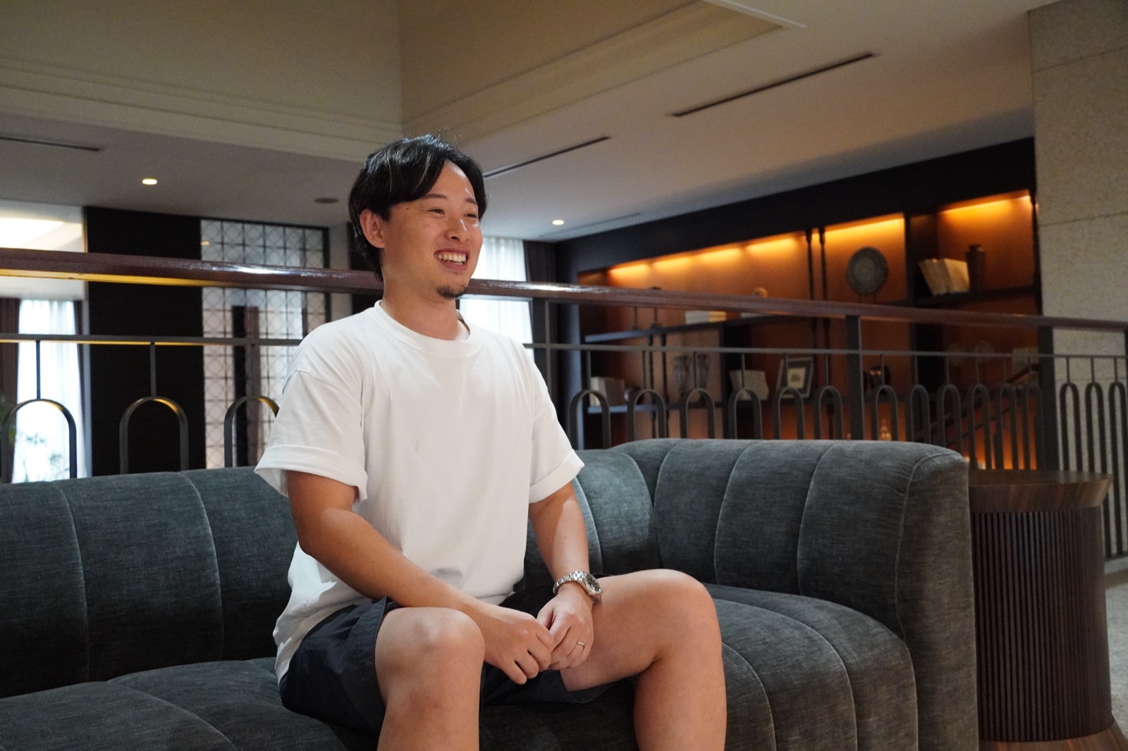 ソファに座ってインタビューに応じる株式会社Nova Clearlyの加納優誉氏