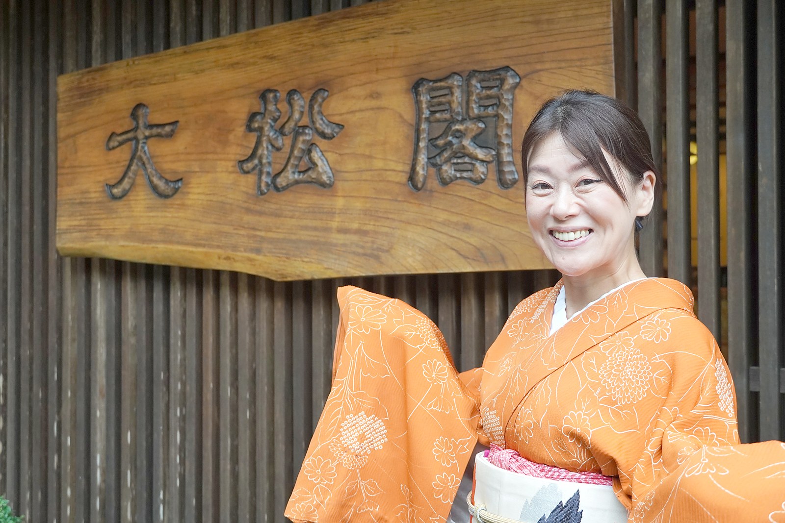 「大松閣」の看板の前に立つ、女将・柏木由香さん