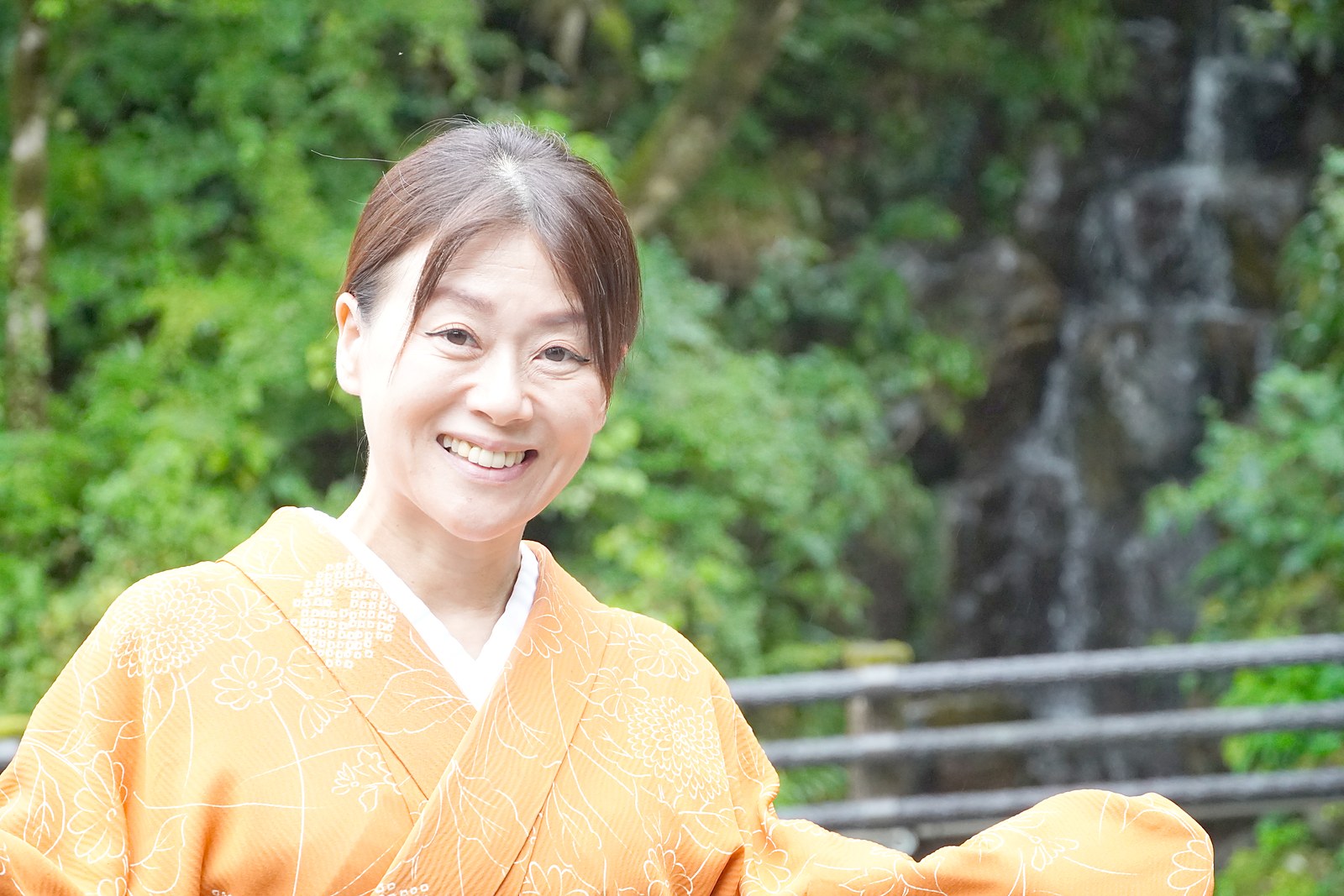名栗の渓谷と滝を背にほほ笑む、名栗温泉・大松閣の女将・柏木由香さん