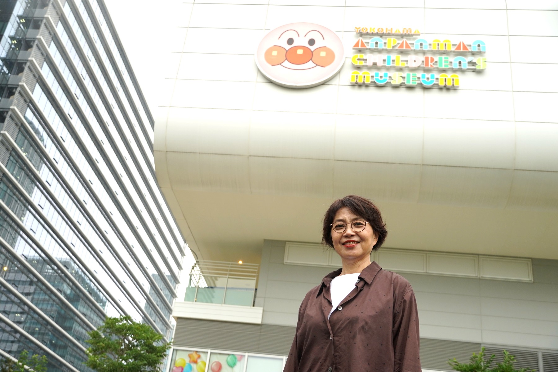 横浜アンパンマンこどもミュージアムを背景に立つ三浦さん