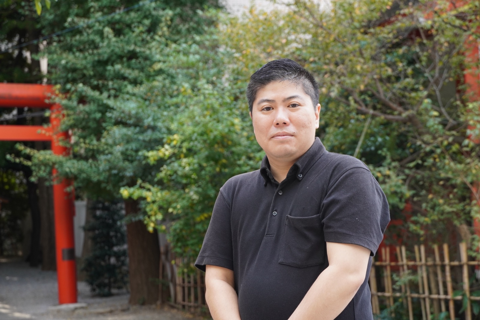 花園神社の境内でカメラに向かう渡邉朋宏氏